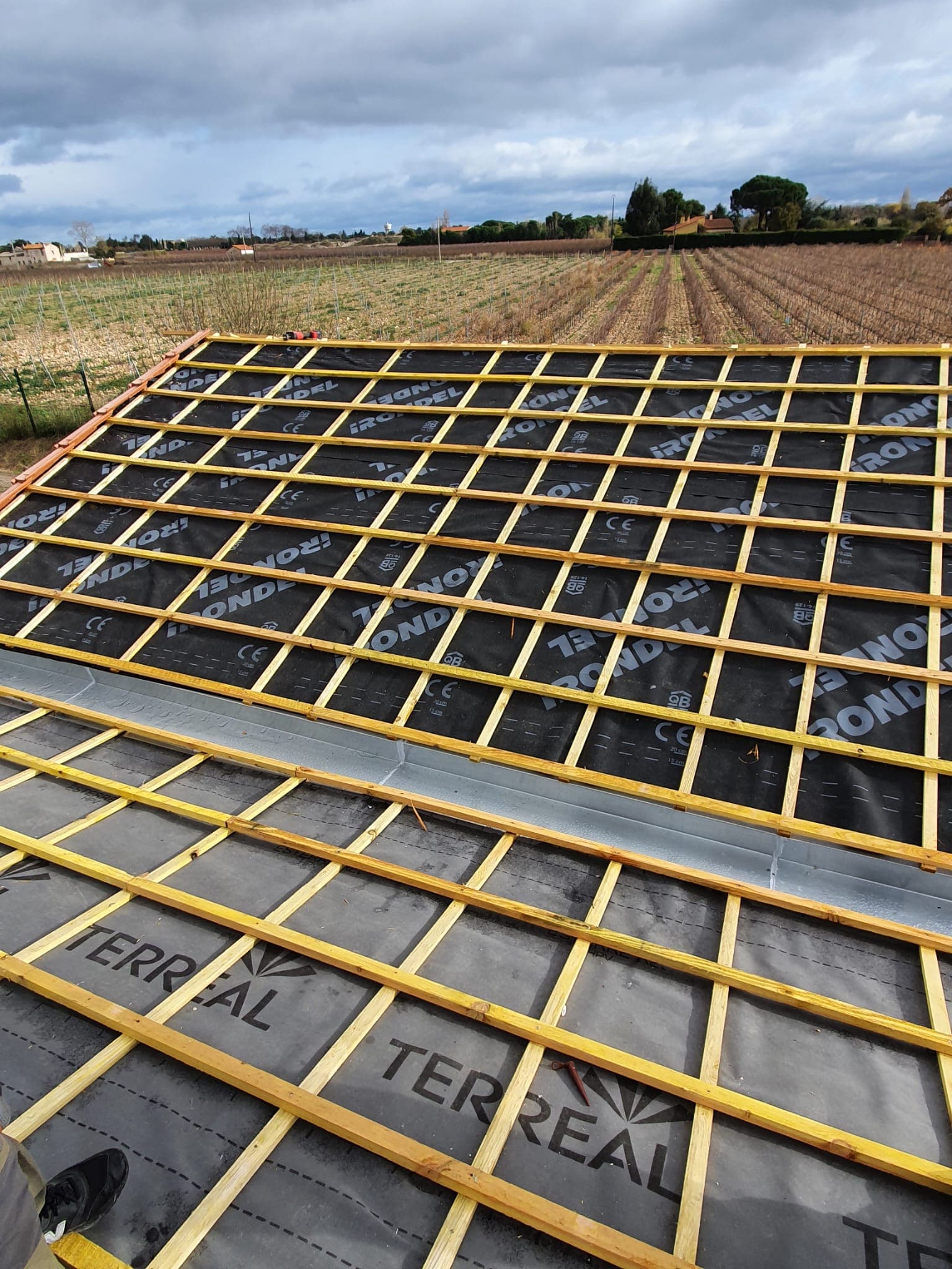 Travaux de couverture avec tuiles en cours de pose